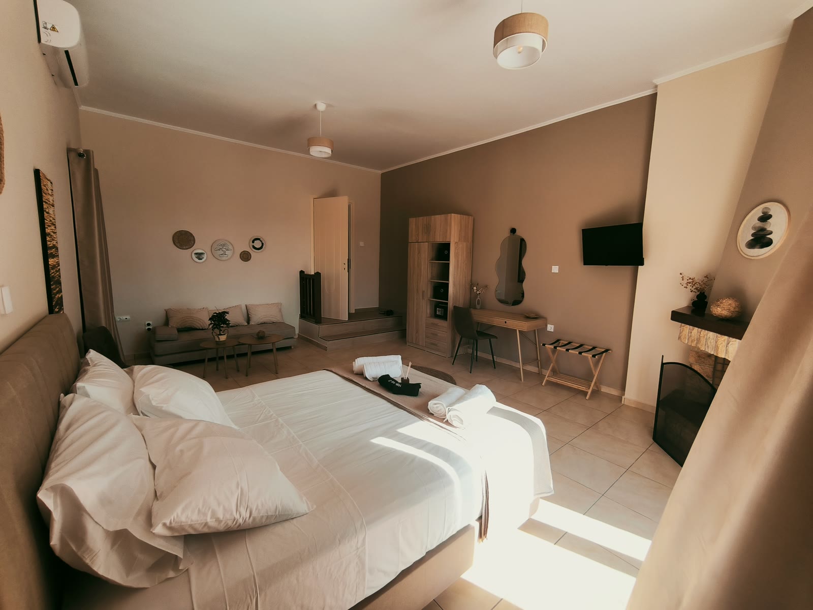 Open living space in a Syros villa — bedroom, sofa and desk for a month-long stay